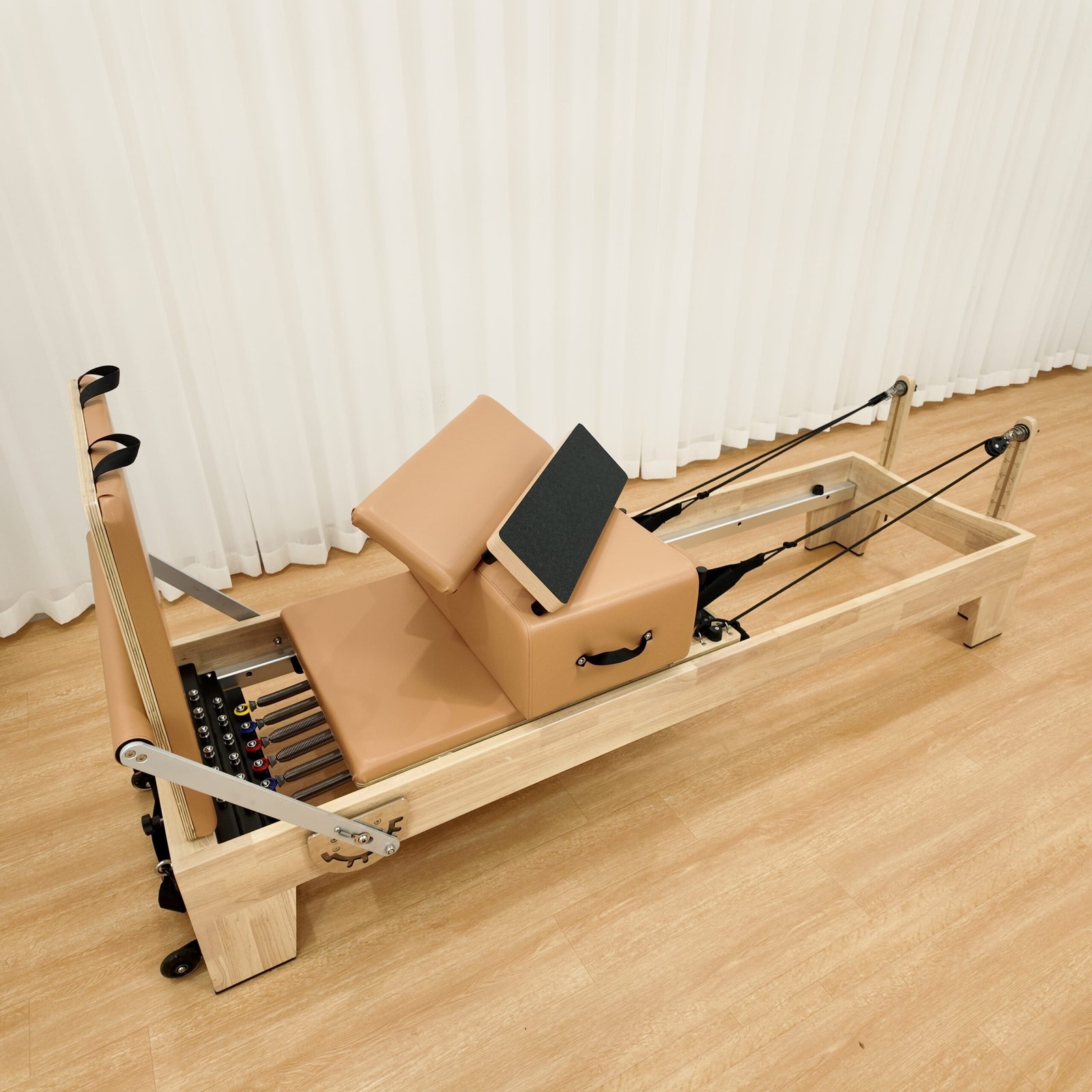 Side view of solid oak wood Pilates Reformer with wooden frame