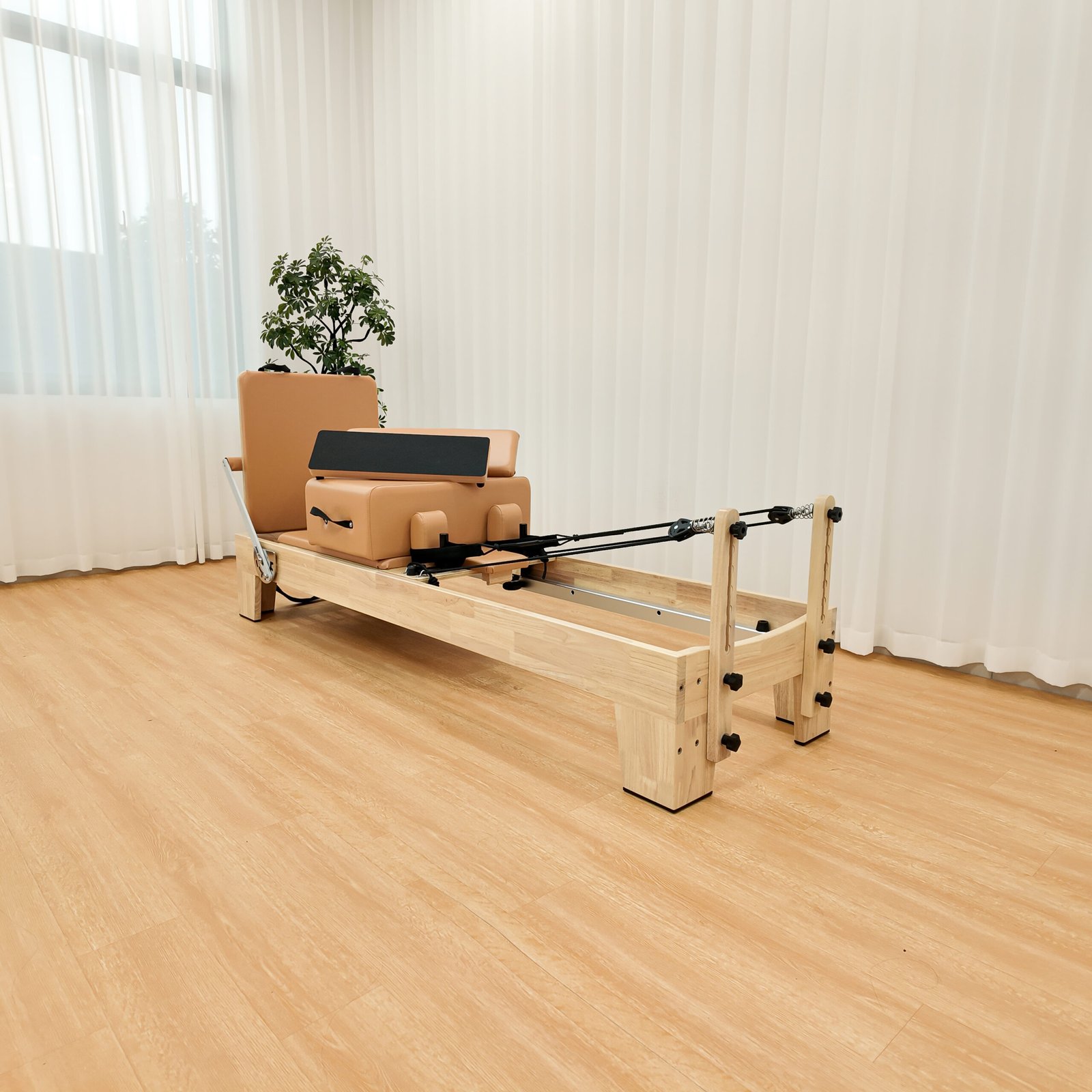 Side view of solid oak wood Pilates Reformer with wooden frame